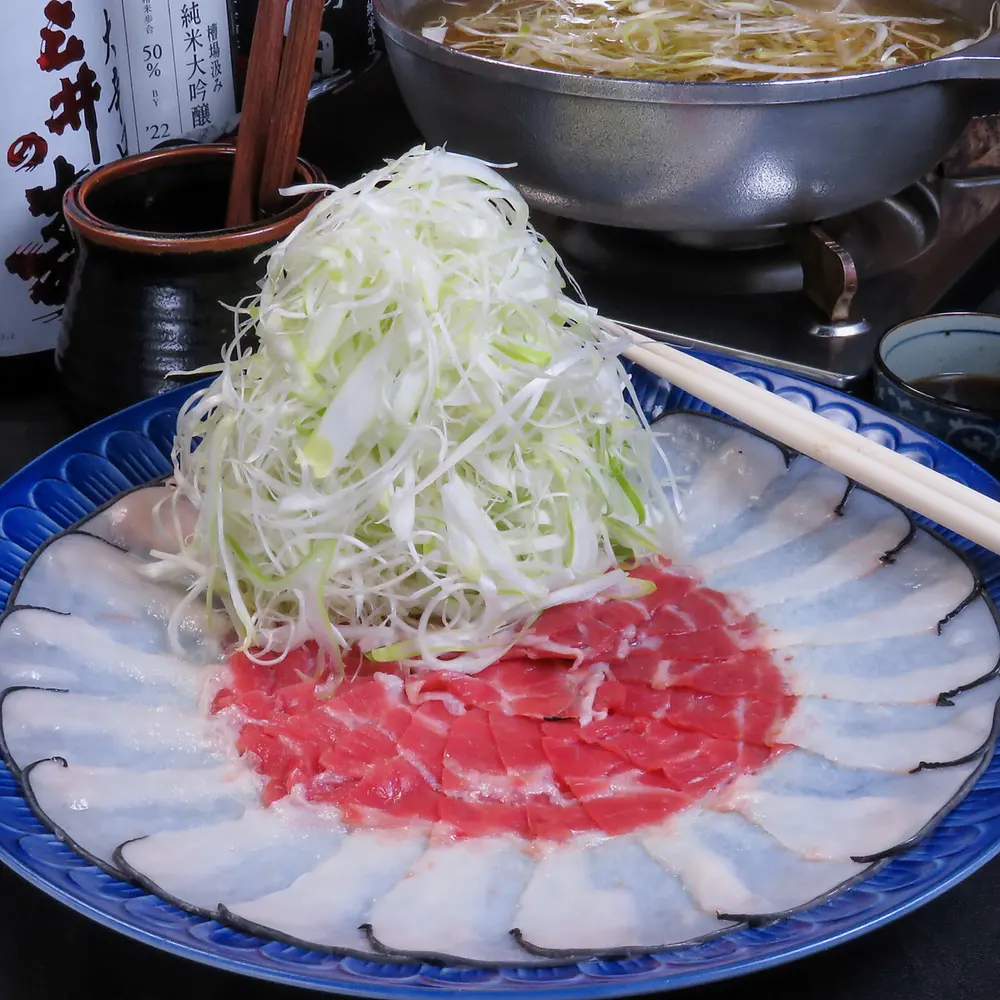 藍の大皿に輪に並べた鯨の生うねと、山盛りの白髪葱